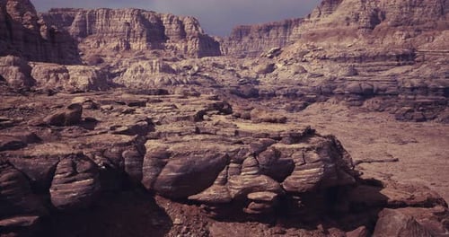 A Rugged Landscape Showcases Intricate Rock Formations Under a Cloudy Sky