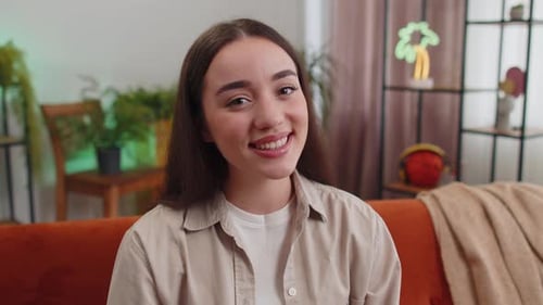 Smiling Woman Relaxing on Couch in Cozy Home