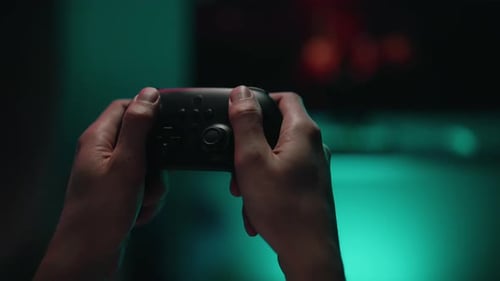 Closeup First Person View of Gamer Hands Holding Using Gamepad Fully Engaged in Intense Videogame