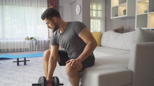 Strong Athletic Man Exercising At Home, Training With Dumbbells.