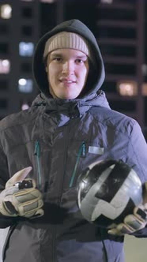 Smiling Man in Urban Setting Holding Soccer Ball