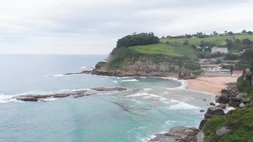 An aerial shot of beautiful beach houses in a scenic rocky beach