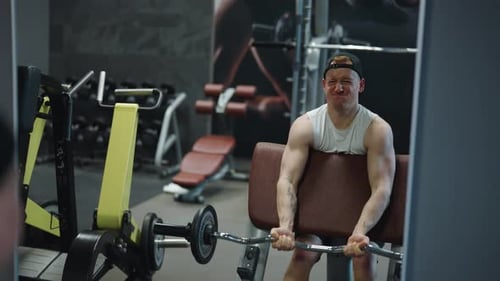 Young Adult Man Bicep Curls in Gym