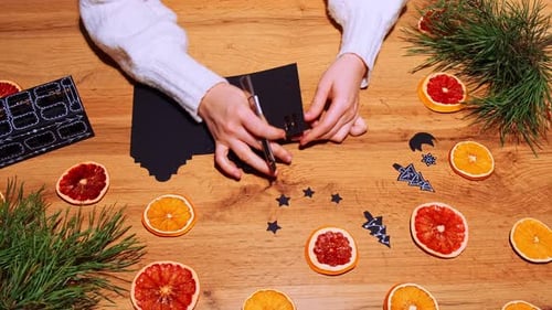 Child Making Holiday Decorations with Paper and Oranges
