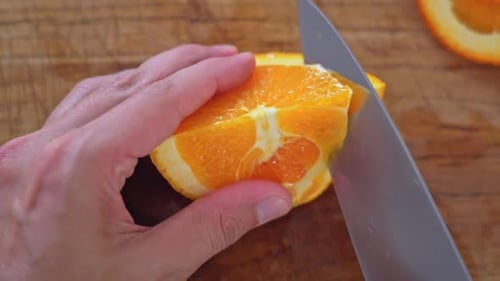 Slicing an Orange with Knife on Cutting Board