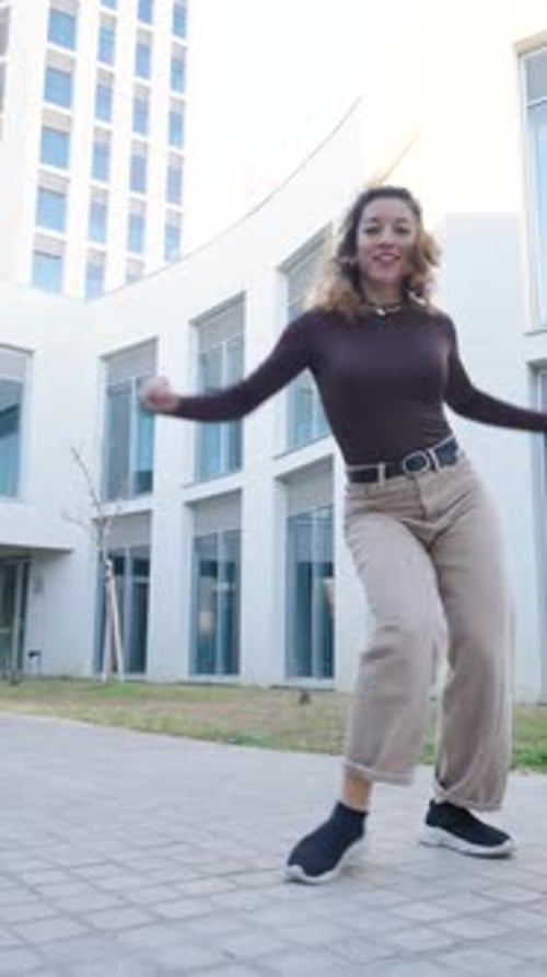 Energetic Woman Dancing with Style in Urban Setting