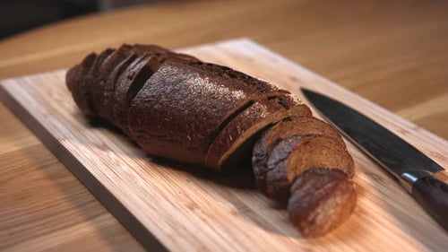 Sliced Dark Rye Bread Loaf on a Wooden Cutting Board Media