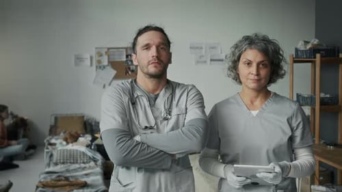 Portrait of Doctor and Nurse Assisting Refugees in Emergency Shelter