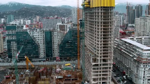 Aerial View of Construction Site with Tower Cranes Working and Building New Skyscraper Apartment