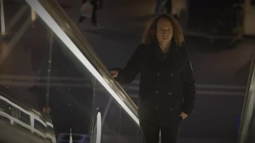 Man with Long Curly Hair Commuting Inside Train Station Watching People