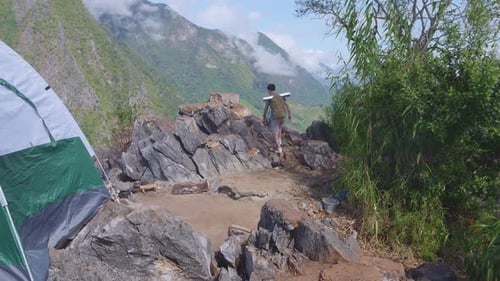 Caminhante asiático masculino caminhando até o topo da montanha nebulosa. Acampar na montanha