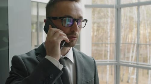 Man in Suit Talking on Phone in Office