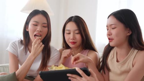 Friends Laughing Watching Tablet Together Inside