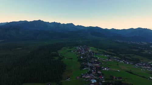 Sunset over tranquil valley and majestic mountains in summer landscape