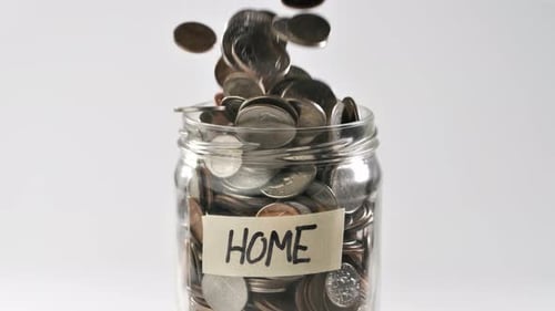 Coins Falling Into Jar Labeled Home