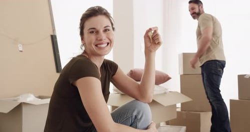 Happy couple, boxes and key for moving in new home, property or investment on apartment together