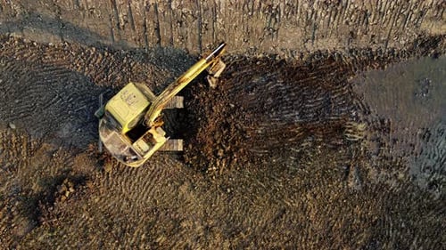 Excavator dig ground at construction site. Aerial view of a wheel loader excavator with a backhoe