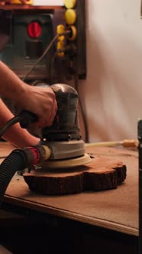 Vertical Video Woodworking Expert in Carpentry Shop Using Angle Grinder to Fix Wooden Surface