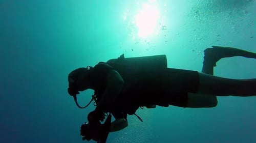 Form eines Tauchers, der in der Silhouette schwimmt, mit kontrastierendem hellgrünem Hintergrund und Atmung