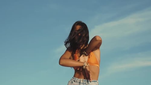 Young Woman Dancing in a Bikini on a Sunny Beach in Slow Motion