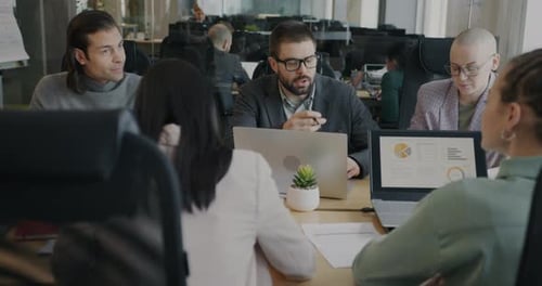 Diverse Team Discusses Data at Modern Office Meeting