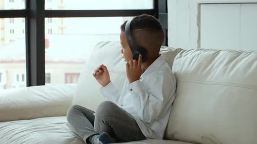 Boy Listening to Music on Couch With Headphones