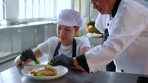 Young Chef Plates Salmon Dish With Guidance