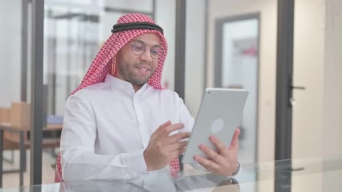 Professional Man Video Calling on Tablet in Office
