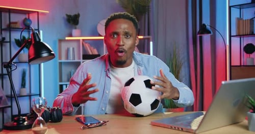 Excited Man Holding Soccer Ball Indoors