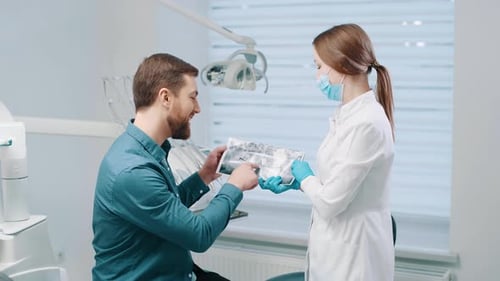 Eine Ärztin bespricht mit einer Patientin einen Plan zur Zahnrestauration und Rehabilitation