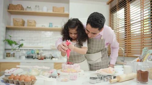 Asian attractive father making cake with daughter in kitchen at house.