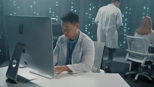 Asian Software Developer in Scientist White Coat Collaborating in Server Office Multiethnic Team of