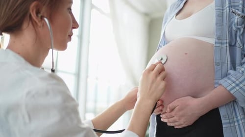 беременная женщина держится за живот, на заднем плане аптека