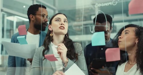 People, writing and notes on glass wall with teamwork, planning and creative brainstorming