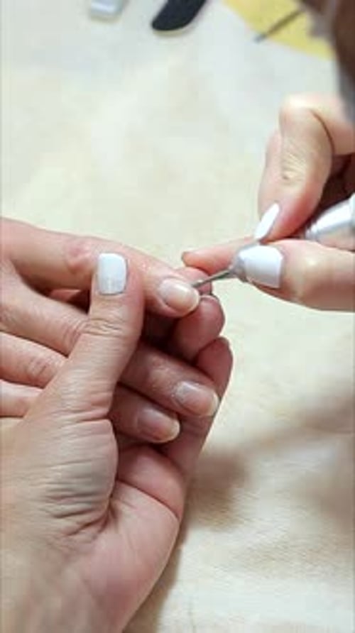 Vertical Video Manicurist Carefully Shapes and Cleans Nails Closeup of Professional Nail Grooming