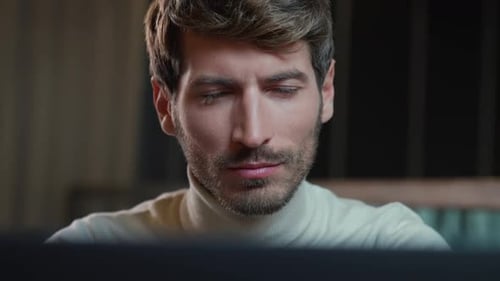 Portrait of a Young Developer Working on a Laptop Focused Man Looks at the Camera the Thinking