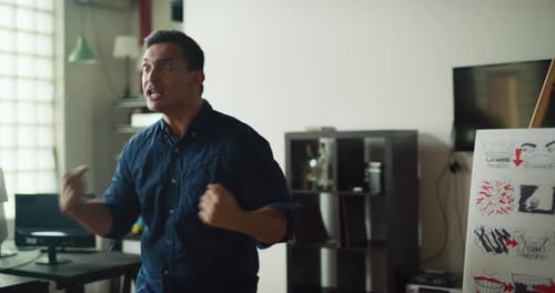 Man Acts Out Sales Pitch Pressentation For Commercial In Modern Well Lit Office During The Day. M...