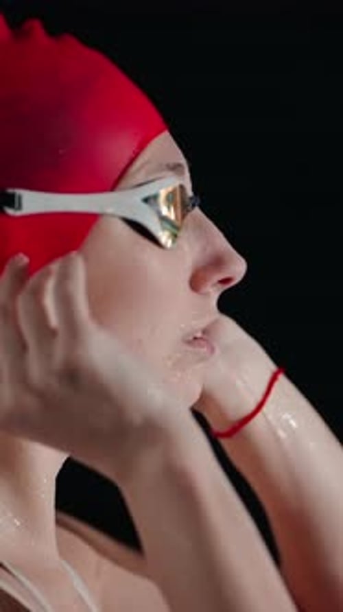 Swimmer Adjusts Goggles Wearing a Red Swim Cap