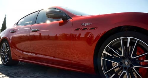Mtskheta, Georgia - August 10 2023: Slider shot of red Maserati Ghibli Trofeo at parking