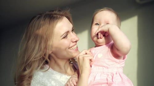 Happy mother embracing her adorable baby girl in a tender moment at home