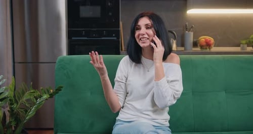 Cheerful Woman Talking on Mobile Phone at Home