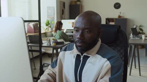Tired Young Black Man in Glasses Working on Computer and Rubbing Eyes