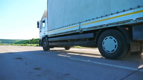 Side View of Truck with Cargo Trailer Driving Along Empty Freeway and Transporting Goods Lorry