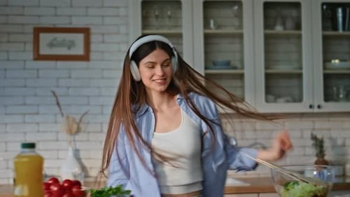 Happy Woman Dancing in Kitchen with Headphones