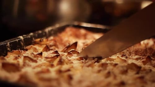Close up of knife cutting delicious apple pie, soft focus handheld