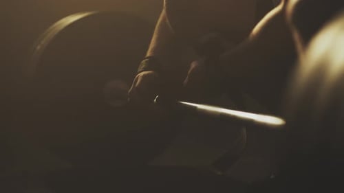 Athlète enroulant des sangles sur une barre