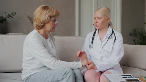 Doctor Holding Hands with Senior Patient at Home