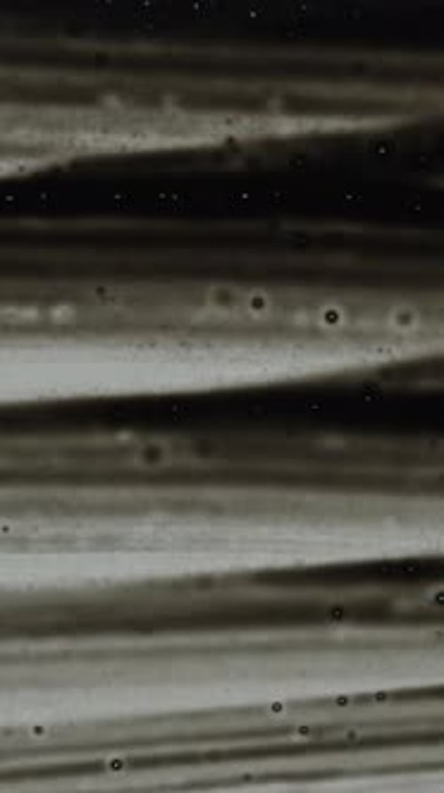 Vertical video. The artist fills the entire screen with black color using a brush. Low angle view