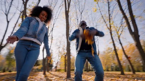 Energetic Woman Encourages Man to Throw Leaves to See Flight