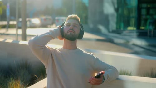 Man Listening to Music on Headphones Outdoors